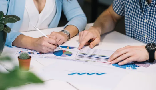 Expert comptable et dirigeant analysant ensemble des graphiques financiers et tableaux de bord de gestion